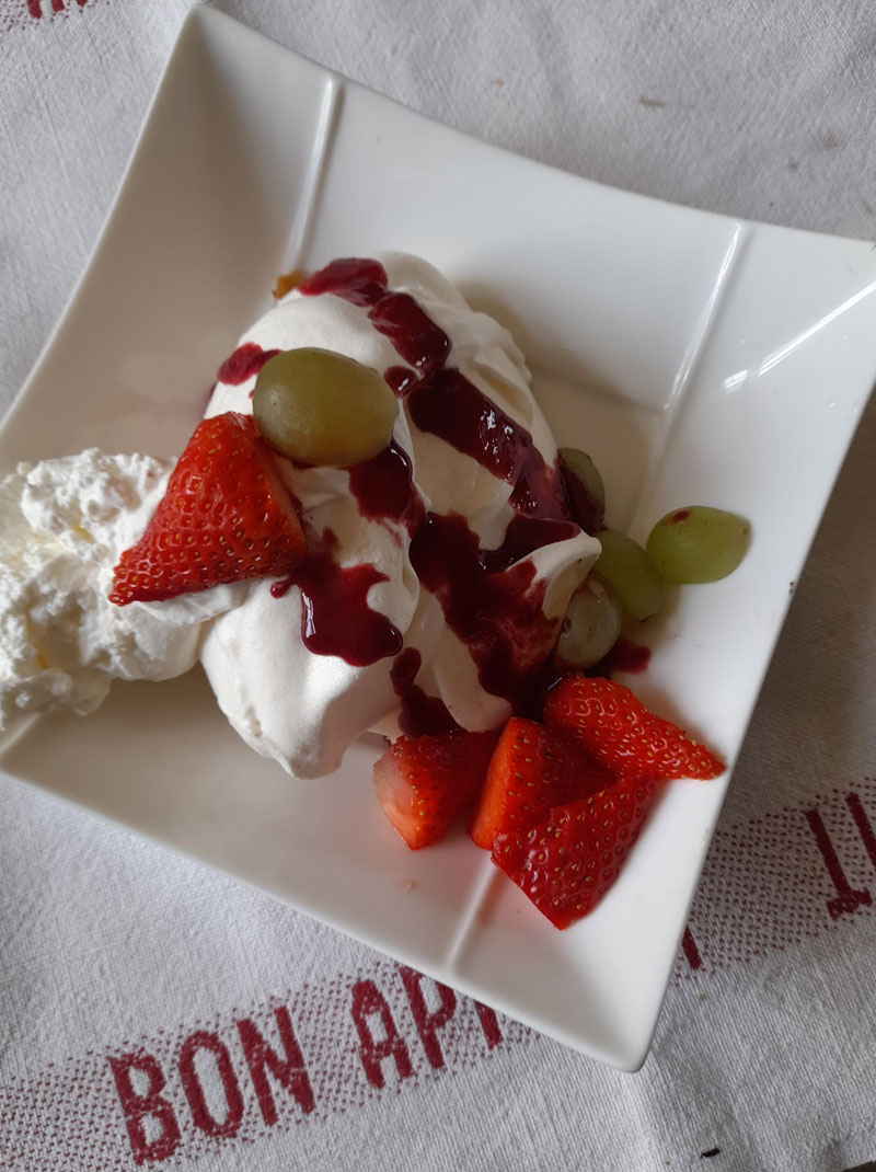 strawberries meringue and cream served on a square plate