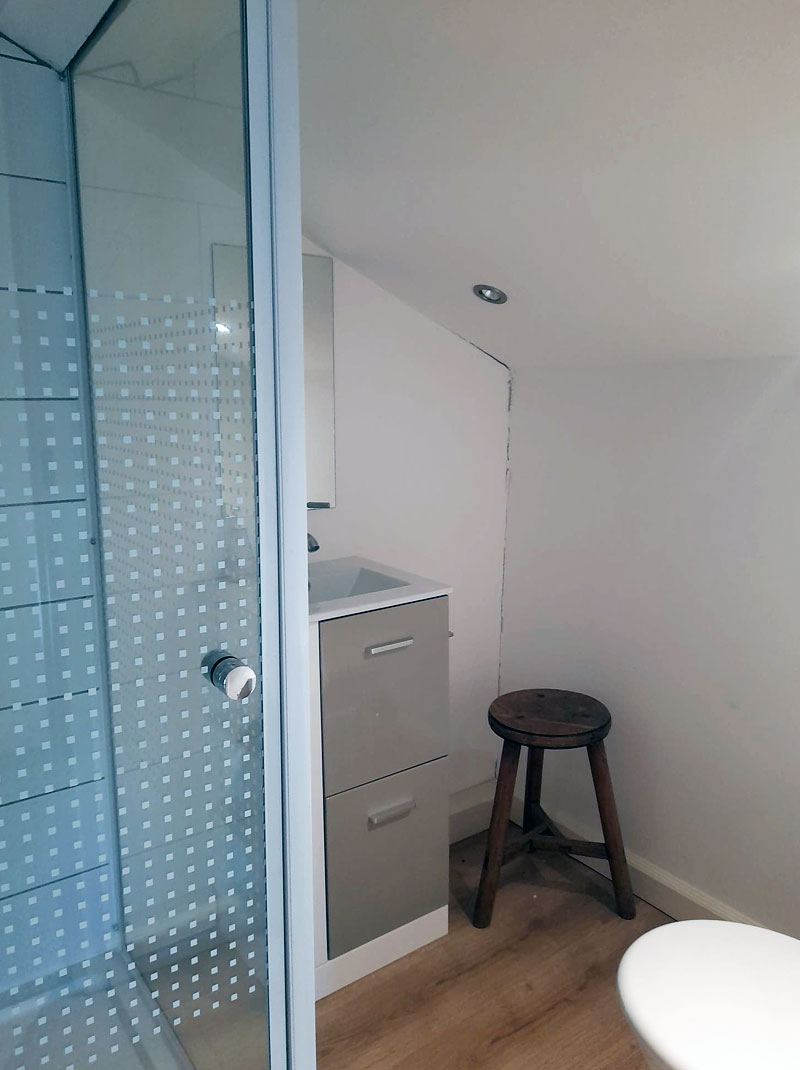 white walled bathroom with shower cubicle and sink