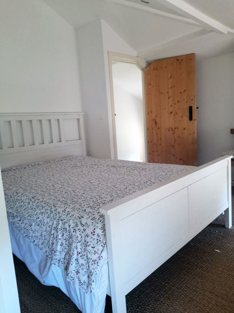 bright bedroom with white framed double bed